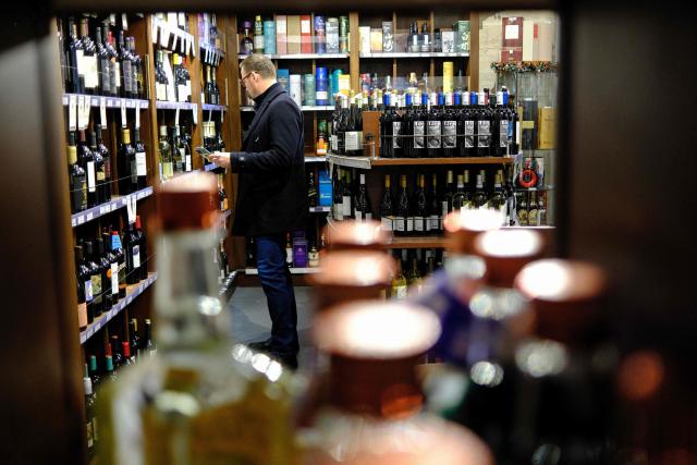 People shop in a liquor store in the Manhattan borough of New York City on December 13, 2025. (Photo by CHARLY TRIBALLEAU / AFP)
