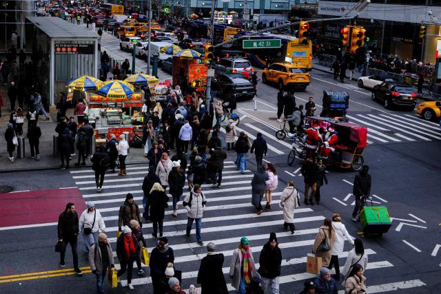 People walk along Sixth Avenue and 42nd street in the Manhattan borough of New York City on December 13, 2025. (Photo by CHARLY TRIBALLEAU / AFP)