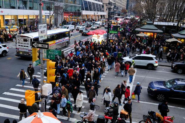 People walk along Sixth Avenue and 42nd street in the Manhattan borough of New York City on December 13, 2025. (Photo by CHARLY TRIBALLEAU / AFP)