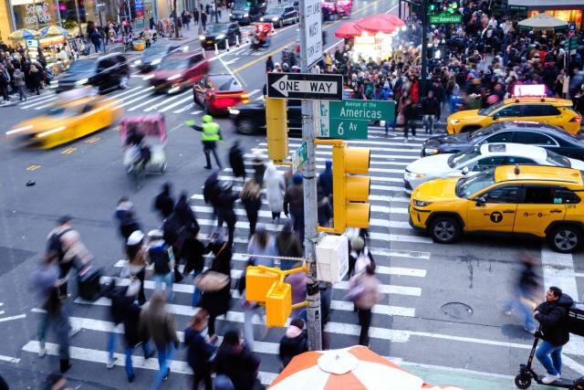 People walk along Sixth Avenue and 42nd street in the Manhattan borough of New York City on December 13, 2025. (Photo by CHARLY TRIBALLEAU / AFP)