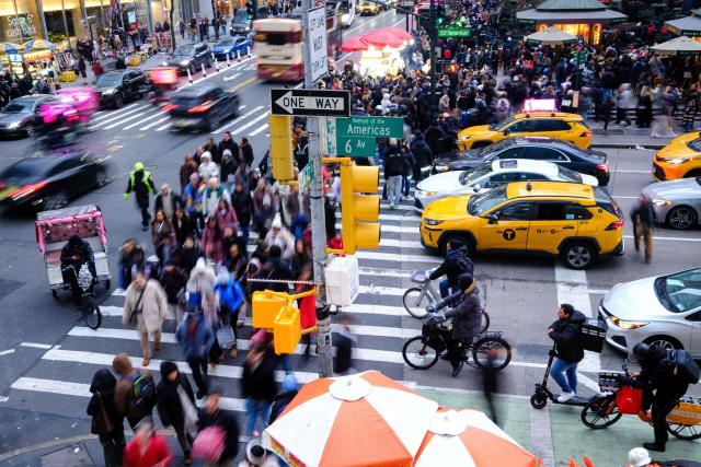People walk along Sixth Avenue and 42nd street in the Manhattan borough of New York City on December 13, 2025. (Photo by CHARLY TRIBALLEAU / AFP)