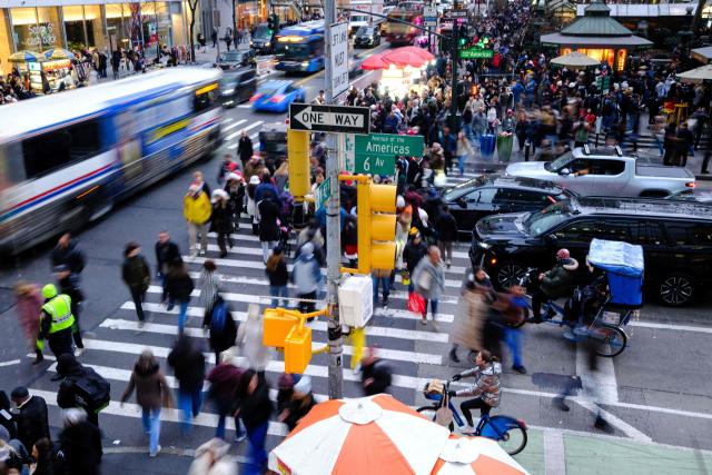 People walk along Sixth Avenue and 42nd street in the Manhattan borough of New York City on December 13, 2025. (Photo by CHARLY TRIBALLEAU / AFP)