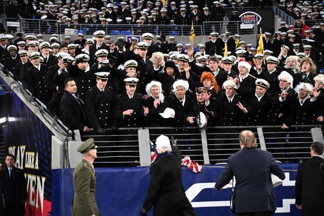 US President Donald Trump throws hats into the crowd at the college football game between the Army and Navy at the M&T Bank Stadium in Baltimore, Maryland, on December 13, 2025. (Photo by Alex WROBLEWSKI / AFP)