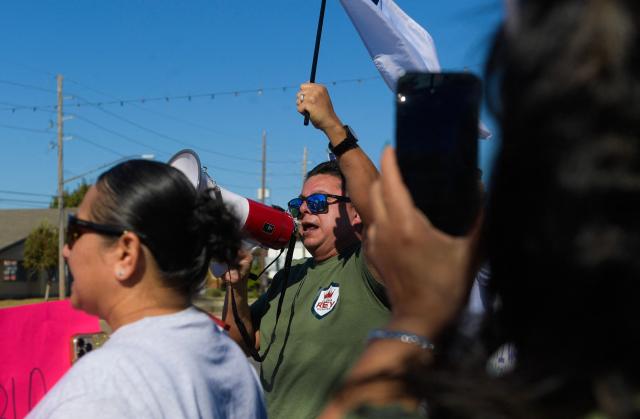 People protest against ICE and Customs and Border Protection near the parking lot of Burlington Coat Factory in Kenner, a suburb of New Orleans, Louisiana, on November 13, 2025. Customs and Border Protection agents made arrests near the Burlington Coat Factory on December 3rd and 4th after launching a federal immigration enforcement operation, named "Operation Catahoula Crunch", in the New Orleans, Louisiana area. (Photo by Matthew Hatcher / AFP)