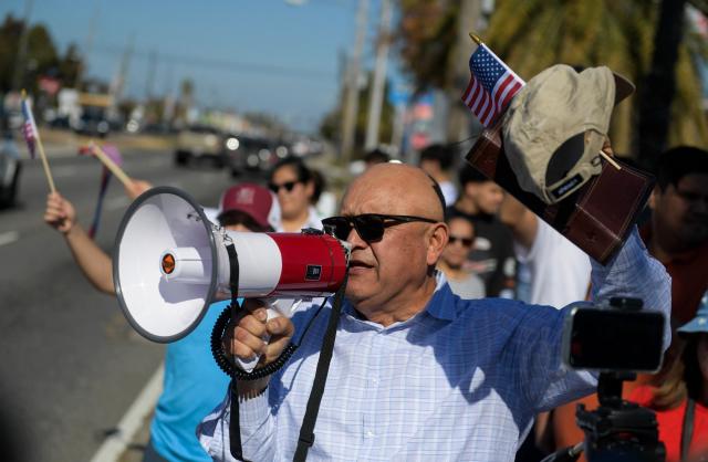 People protest against ICE and Customs and Border Protection near the parking lot of Burlington Coat Factory in Kenner, a suburb of New Orleans, Louisiana, on November 13, 2025. Customs and Border Protection agents made arrests near the Burlington Coat Factory on December 3rd and 4th after launching a federal immigration enforcement operation, named "Operation Catahoula Crunch", in the New Orleans, Louisiana area. (Photo by Matthew Hatcher / AFP)