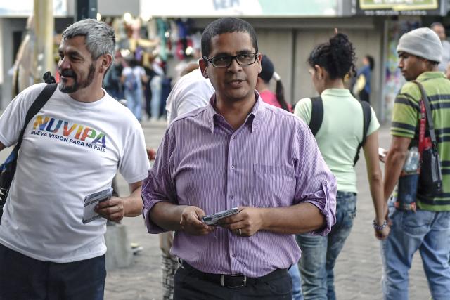 (FILES) Venezuelan candidate for the mayoralty of Libertador, Nicmer Evans (C), speaks with people in the streets while campaigning in Caracas on November 20, 2017. The director of the digital media outlet Punto de Corte, Nicmer Evans, was arrested in Venezuela on December 13, 2025, according to reports from his wife and various NGOs, after intelligence police took him from his home in Caracas. (Photo by JUAN BARRETO / AFP)