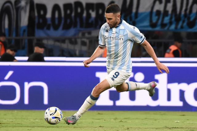 Racing's forward #09 Adrian Martinez prepares to shoot the ball and scoring his team's first goal during the Argentine Professional Football League 2025 Clausura Tournament final match between Racing and Estudiantes at the Madre de Ciudades stadium in Santiago del Estero, Argentina on December 13, 2025. (Photo by Luis Santillan / AFP)