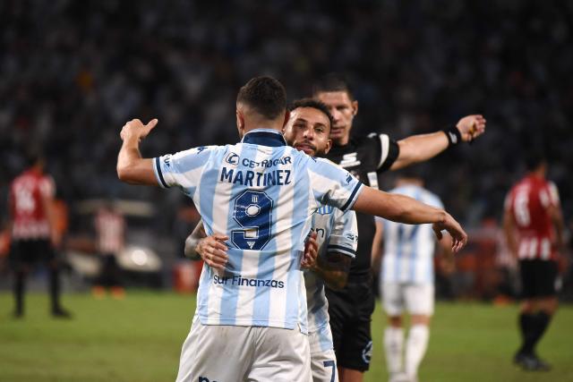 Racing's forward #09 Adrian Martinez celebrates with teammate Colombian forward #07 Duvan Vergara after scoring his team's first goal during the Argentine Professional Football League 2025 Clausura Tournament final match between Racing and Estudiantes at the Madre de Ciudades stadium in Santiago del Estero, Argentina on December 13, 2025. (Photo by Luis Santillan / AFP)