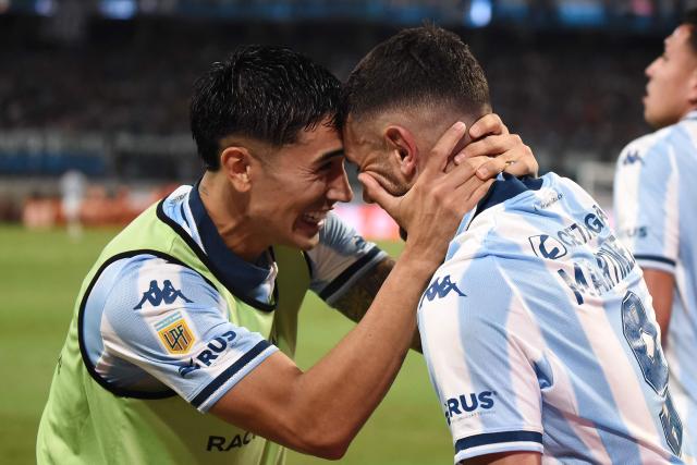 Racing's forward #09 Adrian Martinez (R) celebrates with a teammate after scoring his team's first goal during the Argentine Professional Football League 2025 Clausura Tournament final match between Racing and Estudiantes at the Madre de Ciudades stadium in Santiago del Estero, Argentina on December 13, 2025. (Photo by Luis Santillan / AFP)