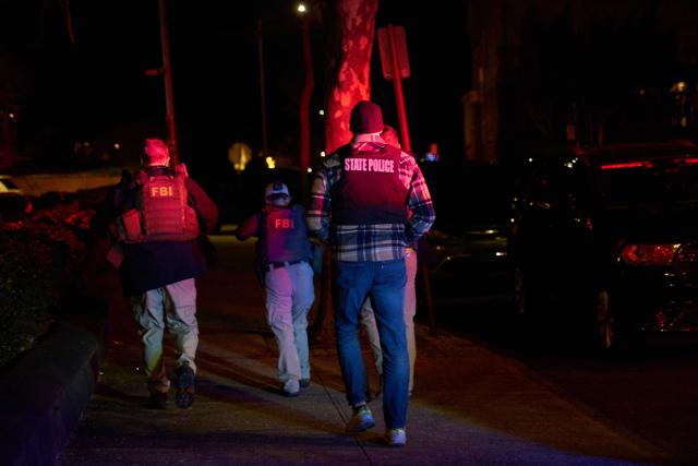 Law enforcement officers arrive to the Barus & Holley engineering building at Brown University campus in Providence, Rhode Island, on December 13, 2025. A gunman killed two people and critically wounded eight others in the afternoon of December 13 at prestigious Brown University, authorities said, urging people in the area to remain in lockdown as the attacker was still at large. (Photo by Bing Guan / AFP)