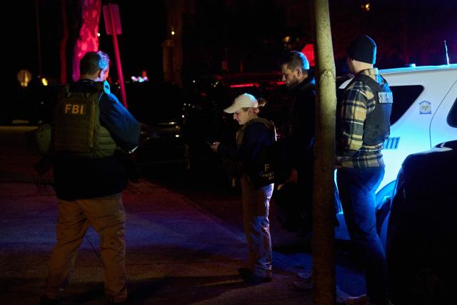 Law enforcement officers gather outside the Barus & Holley engineering building at Brown University campus in Providence, Rhode Island, on December 13, 2025. A gunman killed two people and critically wounded eight others in the afternoon of December 13 at prestigious Brown University, authorities said, urging people in the area to remain in lockdown as the attacker was still at large. (Photo by Bing Guan / AFP)