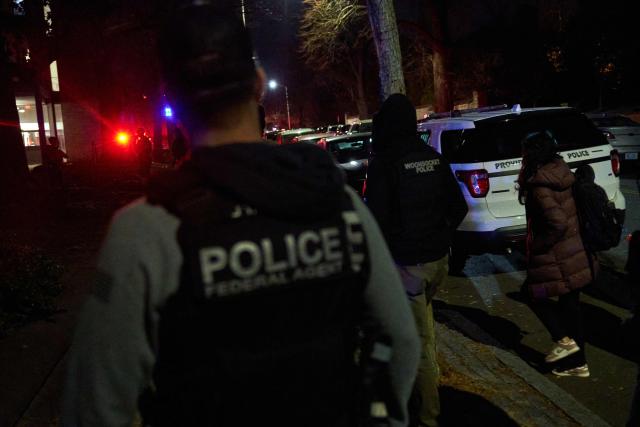 Law enforcement officers escort students near the Barus & Holley engineering building at Brown University campus in Providence, Rhode Island, on December 13, 2025. A gunman killed two people and critically wounded eight others in the afternoon of December 13 at prestigious Brown University, authorities said, urging people in the area to remain in lockdown as the attacker was still at large. (Photo by Bing Guan / AFP)