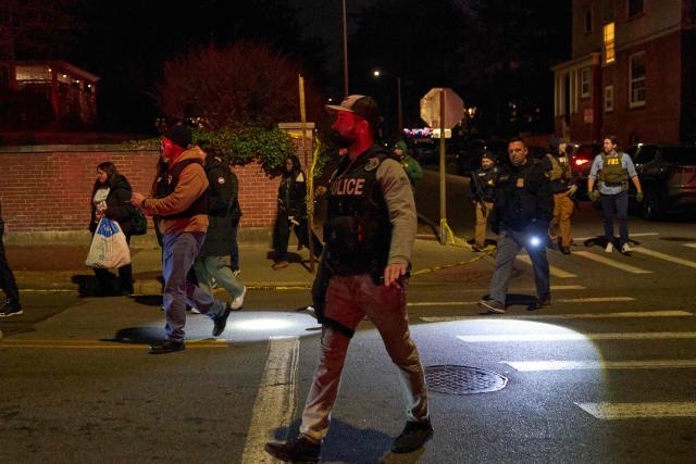 Law enforcement officers escort students near the Barus & Holley engineering building at Brown University campus in Providence, Rhode Island, on December 13, 2025. A gunman killed two people and critically wounded eight others in the afternoon of December 13 at prestigious Brown University, authorities said, urging people in the area to remain in lockdown as the attacker was still at large. (Photo by Bing Guan / AFP)
