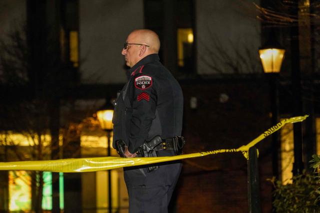 A Brown University police officer stands guard outside the Barus & Holley engineering building at Brown University campus in Providence, Rhode Island, on December 13, 2025. A gunman killed two people and critically wounded eight others in the afternoon of December 13 at prestigious Brown University, authorities said, urging people in the area to remain in lockdown as the attacker was still at large. (Photo by Bing Guan / AFP)