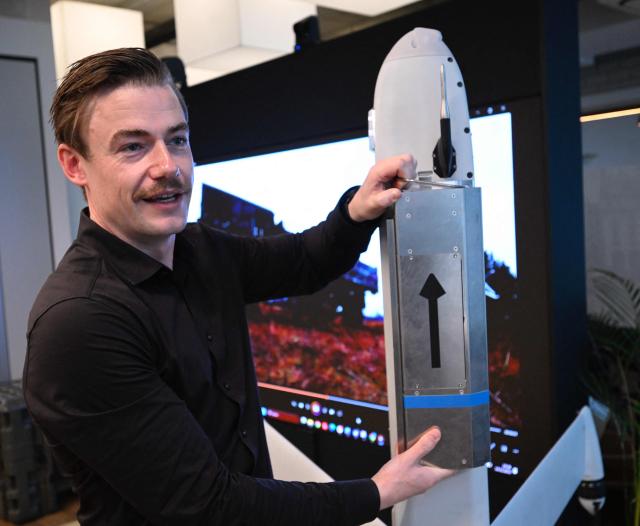 Senior Vice President at German tech defence start-up Stark Josef Kranawetvogl gives explanations on the Virtus strike drone during an AFP interview on December 10, 2025 at the company’s show room in Berlin. Defence giants are drawing battle lines as Germany rearms, with the old guard arguing for a continued focus on traditional heavy weaponry while start-ups push for a shift to more modern kit like AI-enabled drones. (Photo by Tobias SCHWARZ / AFP) / TO GO WITH AFP STORY by Sam Reeves with Femke Colborne