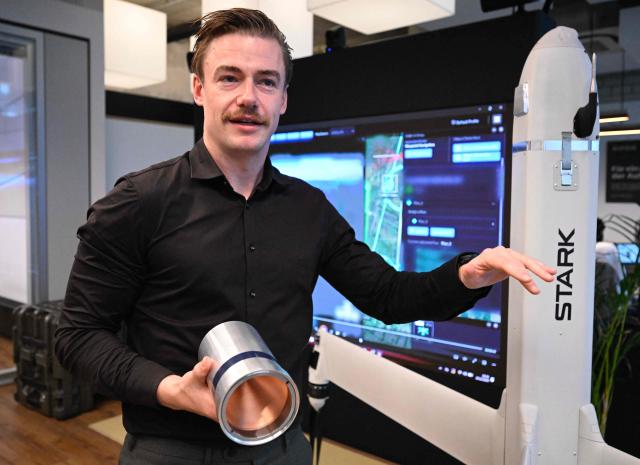 Senior Vice President at German tech defence start-up Stark Josef Kranawetvogl gives explanations on the Virtus strike drone during an AFP interview on December 10, 2025 at the company’s show room in Berlin. Defence giants are drawing battle lines as Germany rearms, with the old guard arguing for a continued focus on traditional heavy weaponry while start-ups push for a shift to more modern kit like AI-enabled drones. (Photo by Tobias SCHWARZ / AFP) / TO GO WITH AFP STORY by Sam Reeves with Femke Colborne