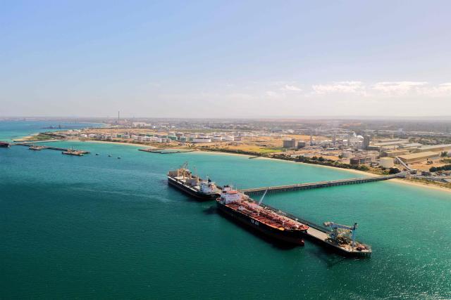 This photo taken on December 12, 2025 shows the oil and chemical tanker Yasa Pelican (R) unloading at Alcoa’s Kwinana berth, near the site designated for Perth’s planned container port, in Perth. The Perth container port is set to move from Fremantle to Kwinana by end of the 2030s. (Photo by Antony DICKSON / AFP)