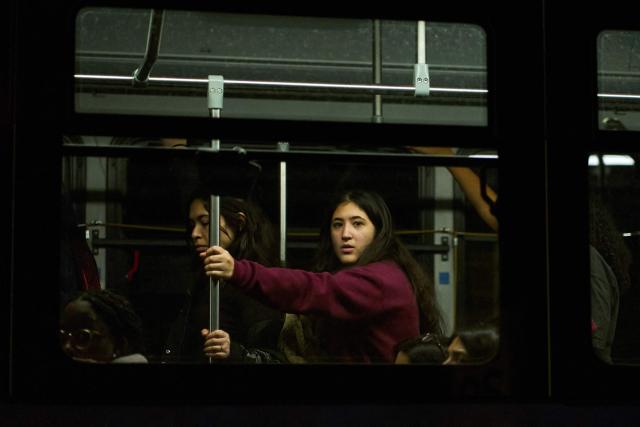 TOPSHOT - Brown University students are evacuated in a public bus after a mass shooting at the Barus & Holley building, home to the engineering and physics departments, in Providence, Rhode Island, on December 13, 2025. A gunman killed two people and critically wounded eight others in the afternoon of December 13 at prestigious Brown University, authorities said, urging people in the area to remain in lockdown as the attacker was still at large. (Photo by Bing Guan / AFP)