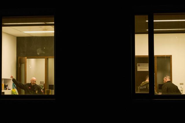 Law enforcement officers are seen inside Kassar House, home of the mathematics department, near the site of a mass shooting at Brown University campus in Providence, Rhode Island, on December 13, 2025. A gunman killed two people and critically wounded eight others in the afternoon of December 13 at prestigious Brown University, authorities said, urging people in the area to remain in lockdown as the attacker was still at large. (Photo by Bing Guan / AFP)