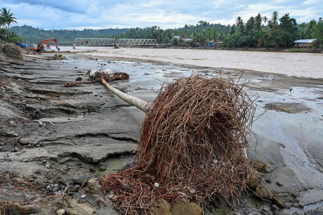 An excavator works near a bridge that was damaged by flooding in Juli, in Indonesia's Aceh province on December 14, 2025. Devastating floods and landslides have killed 1,006 people in Indonesia, rescuers said December 13 as the Southeast Asian nation grapples with the huge scale of relief efforts. (Photo by CHAIDEER MAHYUDDIN / AFP)
