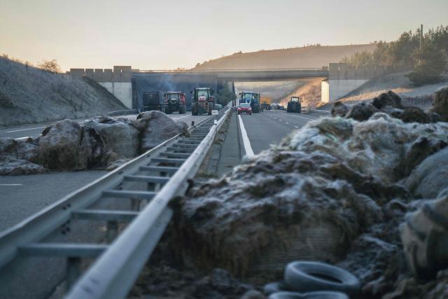 This photograph shows the blockade of farmers who protest the culling of cows due to a skin disease on the A75 motorway in Severac d'Aveyron, central France on December 14, 2025. (Photo by Idriss Bigou-Gilles / AFP)