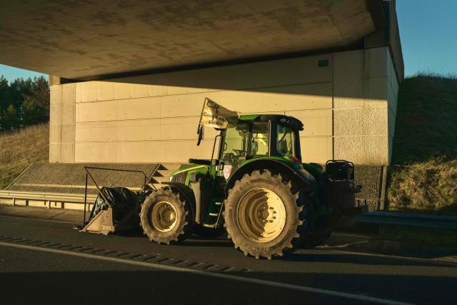 This photograph shows a tractor taking part in the blockade of farmers who protest the culling of cows due to a skin disease on the A75 motorway in Severac d'Aveyron, central France on December 14, 2025. (Photo by Idriss Bigou-Gilles / AFP)