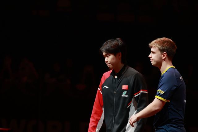 China’s Wang Chuqin (L) and Sweden‘s Truls Moregard leave after it was announced Wang forfeited due to injury before their men’s singles semi-final match during the World Table Tennis (WTT) finals at the Hong Kong Coliseum in Hong Kong on December 14, 2025. (Photo by May JAMES / AFP)