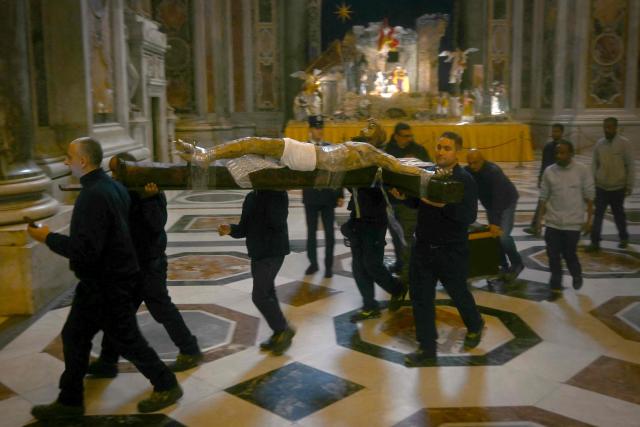 Men carry a crucifix before the start of a mass on the occasion of the Jubilee of Prisoners at St Peter's basilica in The Vatican on December 14, 2025. (Photo by Filippo MONTEFORTE / AFP)