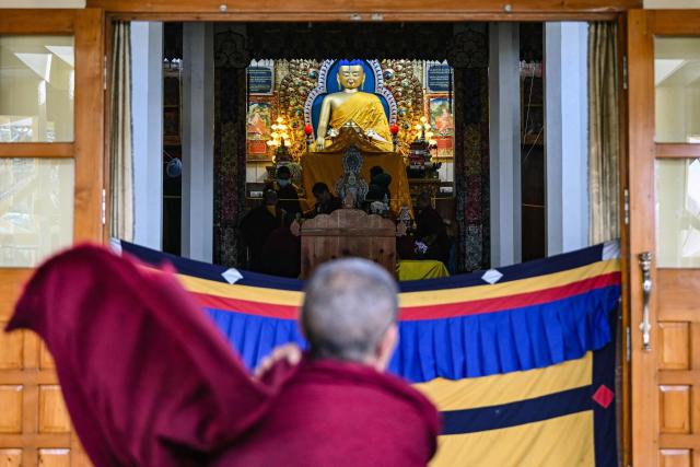 A Buddhist monk arrives to pray at the Tsuk-La-Khang or the Main Tibetan Temple in McLeod Ganj near Dharamsala on December 14, 2025. (Photo by Arun SANKAR / AFP)