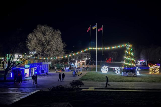 People walk in the street decorated with Christmas illuminations in Zaporizhzhia on December 13, 2025, amid the Russian invasion of Ukraine. (Photo by Darya NAZAROVA / AFP)
