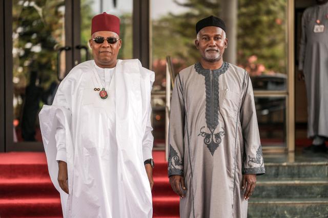 Vice President of Nigeria, Kashim Shettima (L), welcomes Nigeria’s Minister of Foreign Affairs, Yusuf Maitama Tuggar (L), at the Presidential Villa during the 68th Ordinary Session of the Authority of Heads of State and Government of the Economic Community of West African States (ECOWAS) in Abuja on December 14, 2025. (Photo by Light Oriye Tamunotonye / AFP)