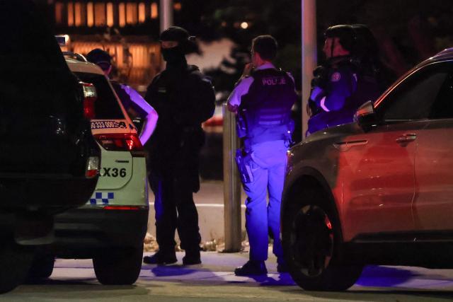 Police stand on a street after a shooting incident at Bondi Beach in Sydney on December 14, 2025. Australian police said two people were in custody following reports of multiple gunshots on December 14 at Sydney's famed Bondi Beach, urging the public to take shelter. (Photo by DAVID GRAY / AFP)