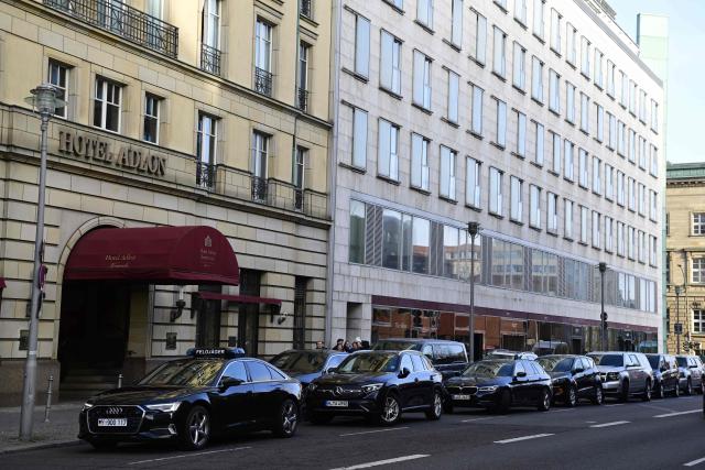 A convoy stands at an entrance of the hotel Adlon on December 14, 2025 in Berlin. Ukrainian President Volodymyr Zelensky is set to travel to Berlin and meet European leaders as well as the heads of the EU and NATO, German government spokesman Stefan Kornelius said. (Photo by John MACDOUGALL / AFP)