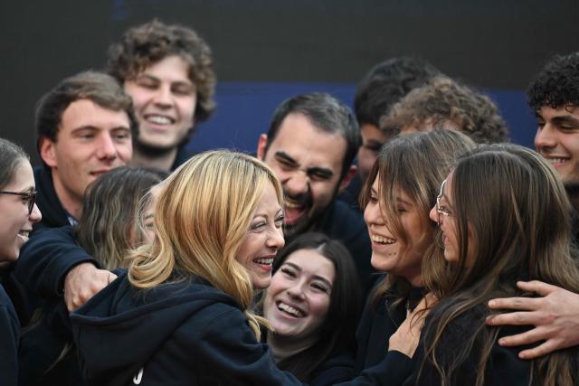 TOPSHOT - Italy's Prime Minister, Giorgia Meloni greets volunteers on stage during the Atreju political meeting organised by the young militants of Italian right wing party Brothers of Italy (Fratelli d'Italia) on December 14, 2025 in Rome. (Photo by Tiziana FABI / AFP)