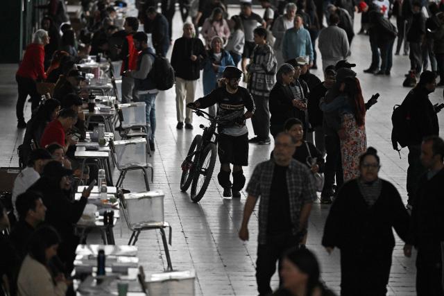 Voters walk around looking for their polling station during the presidential runoff election, at Estacion Mapocho in Santiago on December 14, 2025. Chileans head to the polls for a presidential runoff between Jeannette Jara, a communist backed by a broad left coalition, and Jose Antonio Kast, a devout far-right politico promising a hard line on security and migration. (Photo by EITAN ABRAMOVICH / AFP)