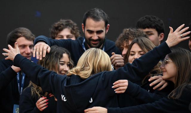 Italy's Prime Minister, Giorgia Meloni greets volunteers on stage during the Atreju political meeting organised by the young militants of Italian right wing party Brothers of Italy (Fratelli d'Italia) on December 14, 2025 in Rome. (Photo by Tiziana FABI / AFP)
