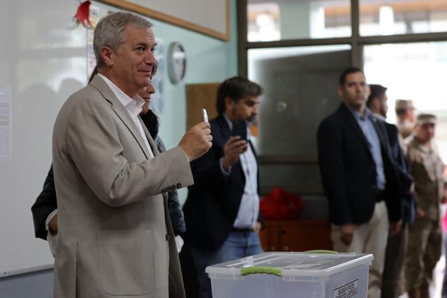 Chile's presidential candidate Jose Antonio Kast, of the Partido Republicano party, poses for a picture with his wife Maria Pia Adriasola before casting his ballot during the presidential runoff election in Paine, south of Santiago, on December 14, 2025. Chileans head to the polls for a presidential runoff between Jeannette Jara, a communist backed by a broad left coalition, and Jose Antonio Kast, a devout far-right politico promising a hard line on security and migration. (Photo by Javier TORRES / AFP)