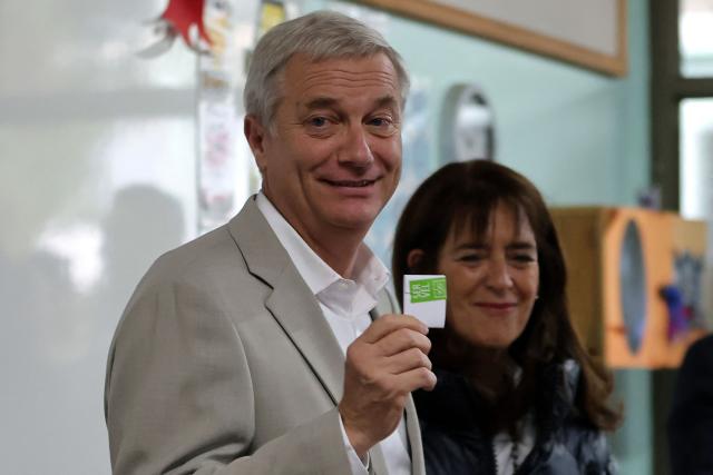 Chile's presidential candidate Jose Antonio Kast (L), of the Partido Republicano party, poses for a picture with his wife Maria Pia Adriasola before casting his ballot during the presidential runoff election in Paine, south of Santiago, on December 14, 2025. Chileans head to the polls for a presidential runoff between Jeannette Jara, a communist backed by a broad left coalition, and Jose Antonio Kast, a devout far-right politico promising a hard line on security and migration. (Photo by Javier TORRES / AFP)