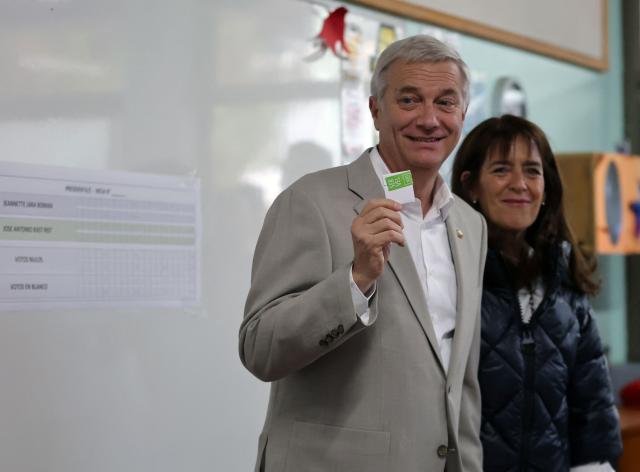 Chile's presidential candidate Jose Antonio Kast (L), of the Partido Republicano party, poses for a picture with his wife Maria Pia Adriasola before casting his ballot during the presidential runoff election in Paine, south of Santiago, on December 14, 2025. Chileans head to the polls for a presidential runoff between Jeannette Jara, a communist backed by a broad left coalition, and Jose Antonio Kast, a devout far-right politico promising a hard line on security and migration. (Photo by Javier TORRES / AFP)