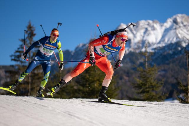 Slovenia's Jakov Fak and Switzerland's Joscha Burkhalter compete during the men's 4x7,5km relay event of the IBU Biathlon World Cup in Hochfilzen, Austria on December 14, 2025. (Photo by GEORG HOCHMUTH / APA / AFP) / Austria OUT
