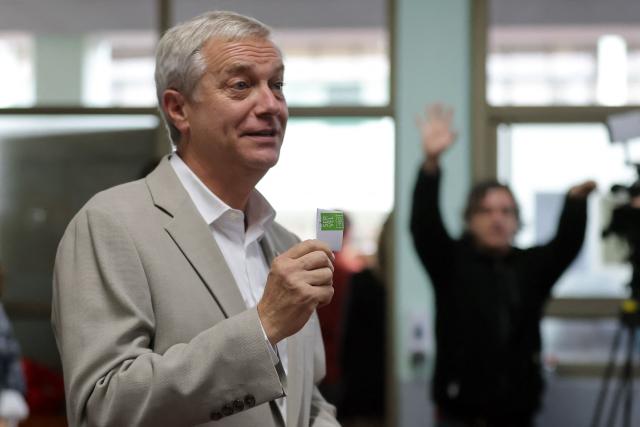 Chile's presidential candidate Jose Antonio Kast, of the Partido Republicano party, poses for a picture before casting his ballot during the presidential runoff election in Paine, south of Santiago, on December 14, 2025. Chileans head to the polls for a presidential runoff between Jeannette Jara, a communist backed by a broad left coalition, and Jose Antonio Kast, a devout far-right politico promising a hard line on security and migration. (Photo by Javier TORRES / AFP)