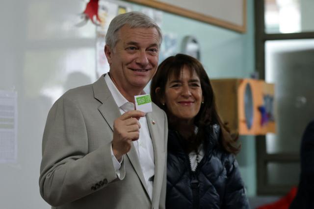 Chile's presidential candidate Jose Antonio Kast, of the Partido Republicano party, poses for a picture with his wife Maria Pia Adriasola before casting his ballot during the presidential runoff election in Paine, south of Santiago, on December 14, 2025. Chileans head to the polls for a presidential runoff between Jeannette Jara, a communist backed by a broad left coalition, and Jose Antonio Kast, a devout far-right politico promising a hard line on security and migration. (Photo by Javier TORRES / AFP)