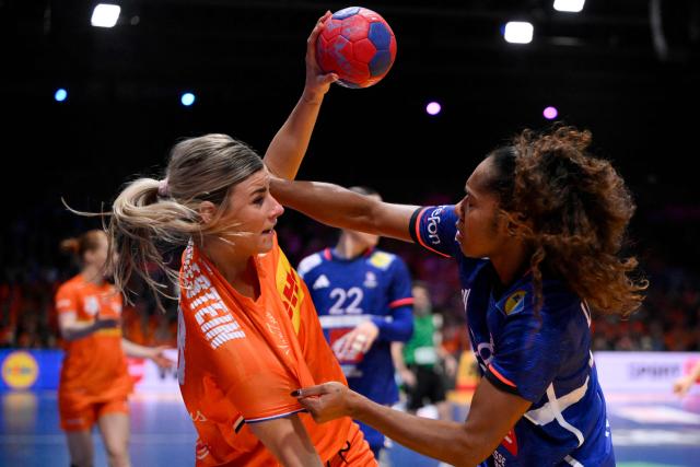 Netherlands' right wing #26 Angela Malestein (L) and France's left wing #98 Suzanne Wajoka fight for the ball during the IHF Women's Handball World Championship match for 3rd place between the Netherlands and France at the Rotterdam Ahoy Arena, in Rotterdam on December 14, 2025. (Photo by JOHN THYS / AFP)