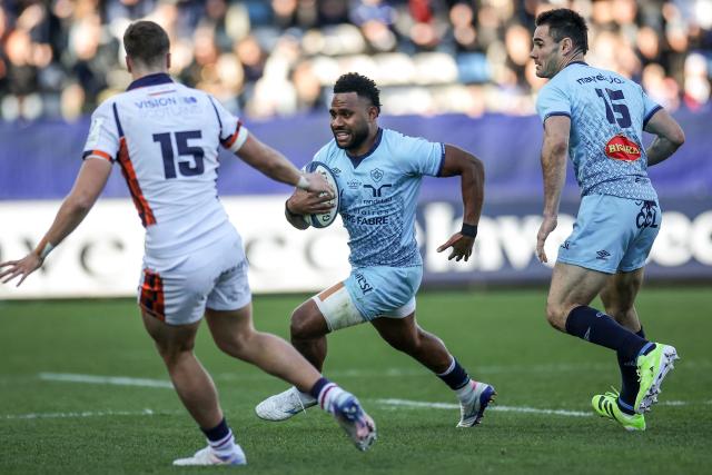 Castres' Fijian centre Vilimoni Botitu (C) runs with the ball during the European Rugby Champions Cup rugby union match between Castres Olympique (FRA) and Edinburgh Rugby (SCO) at Pierre Fabre stadium in Castres on December 14, 2025. (Photo by Valentine CHAPUIS / AFP)