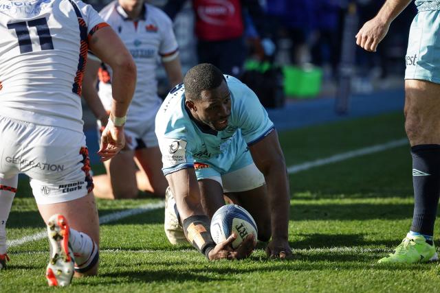 Castres' Cameroonian wing Christian Ambadiang (C) scores his team first try during the European Rugby Champions Cup rugby union match between Castres Olympique (FRA) and Edinburgh Rugby (SCO) at Pierre Fabre stadium in Castres on December 14, 2025. (Photo by Valentine CHAPUIS / AFP)