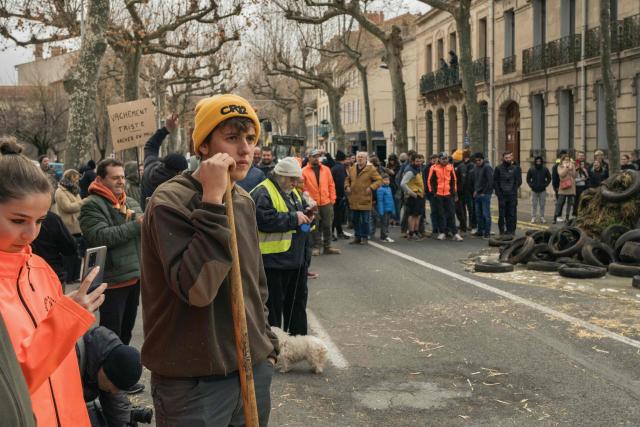 Members of French farmers unions Coordination Rurale and protesters gather outisde Millau's sub-prefecture during a farmers' protest against the policy of slaughtering cows with Contagious Nodular Dermatosis (CND) in Millau, central France, on December 14, 2025. On December 12, 2025 French veterinarians slaughtered a herd of cows thought to be diseased after police dispersed angry farmers trying to protect them, an AFP reporter said, as an agricultural union called for nationwide protests. French farmers are unhappy with the state's management of an outbreak of nodular dermatitis -- widely known as lumpy skin disease. (Photo by Idriss Bigou-Gilles / AFP)