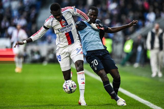 Lyon's Senegalese defender #19 Moussa Niakhate (L) fights for the ball with Le Havre's Tanzanian forward #70 Mbwana Ally Samatta during the French L1 football match between Olympique Lyonnais (OL) and Le Havre AC at the Groupama Stadium in Decines-Charpieu, central-eastern France, on December 14, 2025. (Photo by JEFF PACHOUD / AFP)