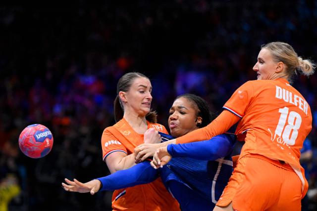 France's pivot #26 Pauletta Foppa (C) fights for the ball with Netherlands' centre back #09 Larissa Nusser (L) and Netherlands' left back #18 Kelly Dulfer during the IHF Women's Handball World Championship match for 3rd place between the Netherlands and France at the Rotterdam Ahoy Arena, in Rotterdam on December 14, 2025. (Photo by JOHN THYS / AFP)