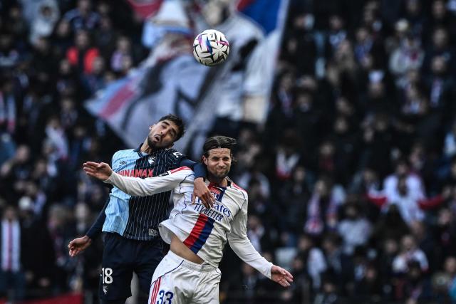 Lyon's Dutch defender #33 Hans Hateboer (R) fights for the ball with Le Havre's French defender #18 Yanis Zouaoui during the French L1 football match between Olympique Lyonnais (OL) and Le Havre AC at the Groupama Stadium in Decines-Charpieu, central-eastern France, on December 14, 2025. (Photo by JEFF PACHOUD / AFP)