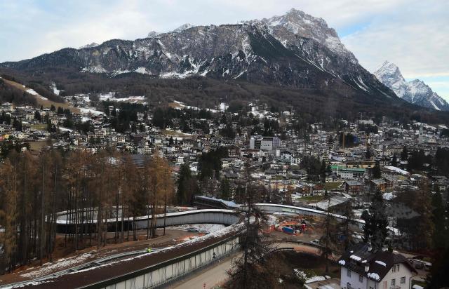 A picture shows the Cortina Sliding Centre, which will host bobsleigh, skeleton and luge competitions and Cortina d'Ampezzo valley in the background, ahead of the Milano Cortina 2026 Olympic Games, on December 11, 2025. (Photo by Stefano RELLANDINI / AFP)